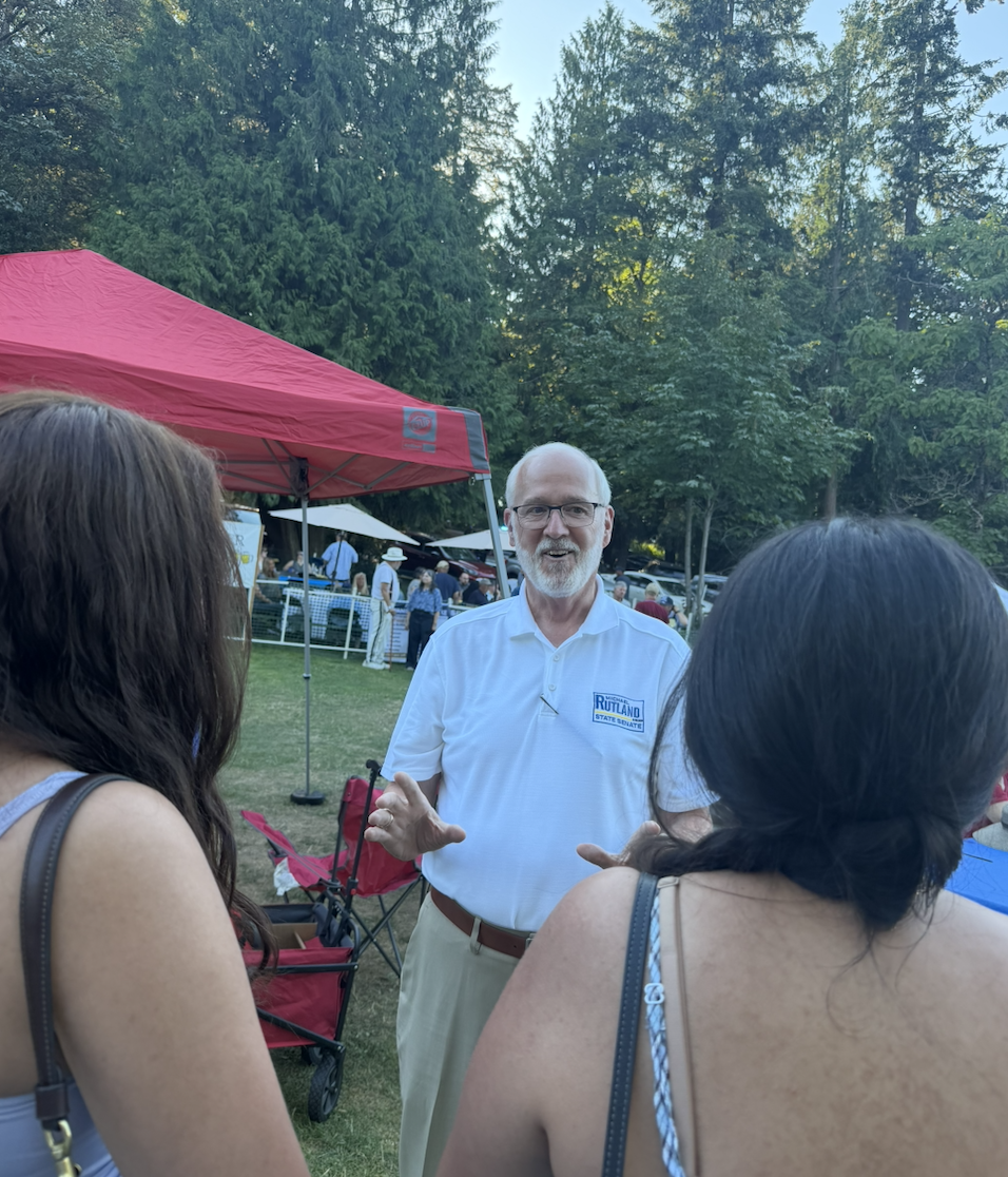 Michael Rutland talking with voters at an outdoor event