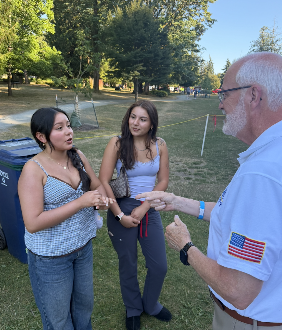 Michael Rutland speaking with young voters at a park