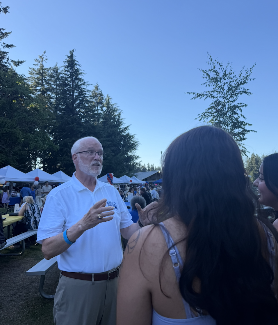 Michael Rutland speaking with attendees at an evening community event