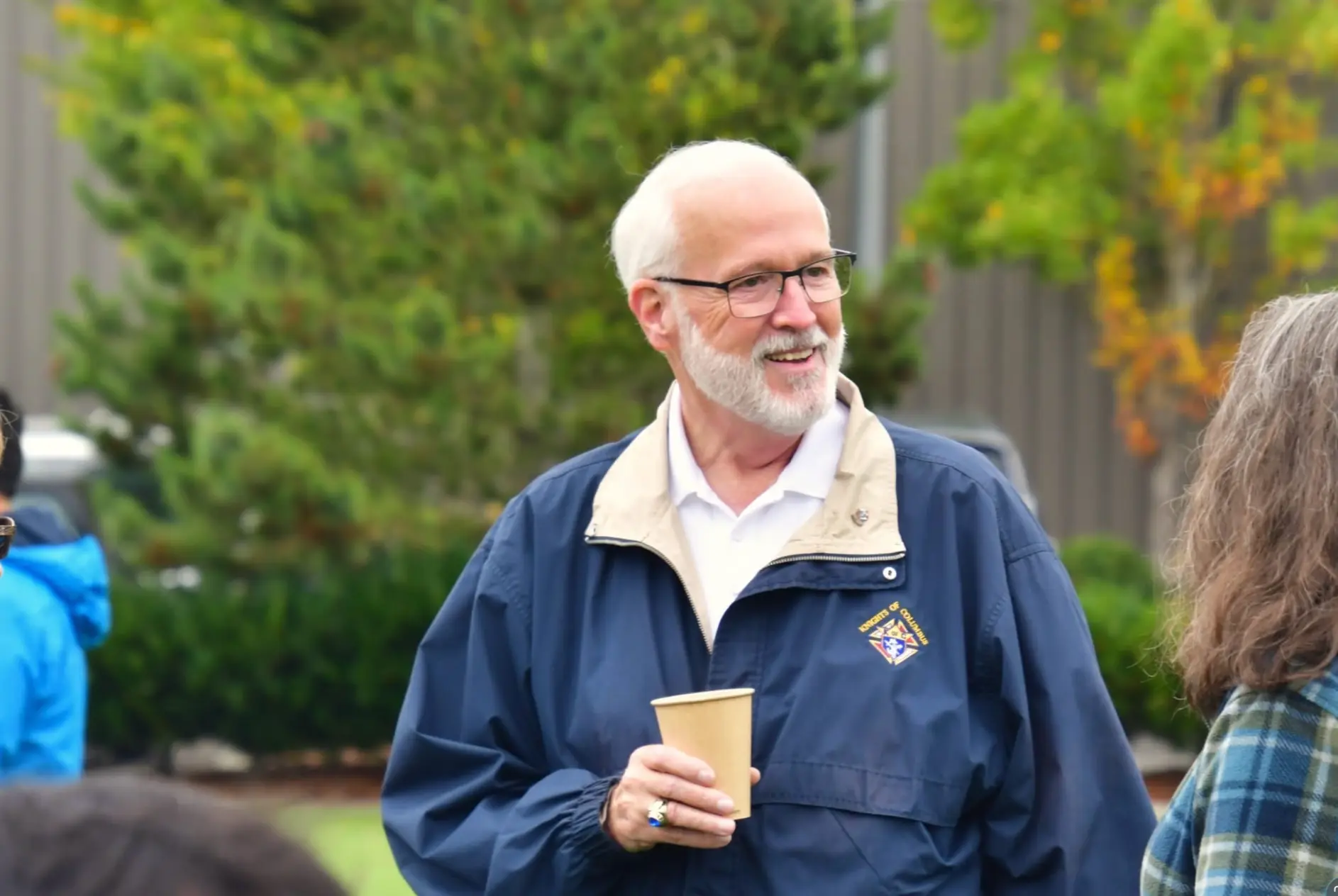 Michael Rutland in his Knights of Columbia jacket at an outdoor community gathering